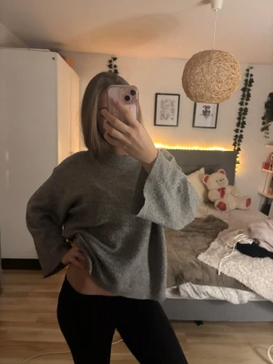 Grå oversized stickad tröja - Mysig grå stickad tröja med oversized passform och vida ärmar. Tröjan har rund halsringning och är tillverkad i ett mjukt material. Enkel och stilren design som är lätt att matcha.