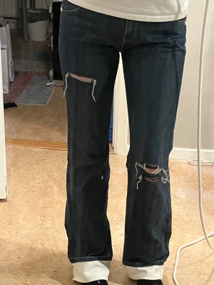 Mörkblå bootcut/raka jeans  - Dessa jeans köpte jag second hand och förlängde till min önskade längd på byxa samt gjorde hålen själv. Dem är i mid waist och är väldigt bekväma.  Dem är i storlek 28/34 och har ett innerbensmått på ca 84cm samt 41cm i midjan tvärs över. Hör av dig vid frågor 🤗🫶