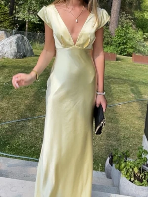 Ljusgul långklänning med v-ringning - Säljer min eftertraktade balklänning som endast är använd en gång och inte har några defekter. Är 165 cm och längden är perfekt på mig
