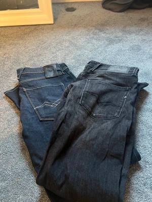 2st Svarta Replay jeans med tvätt - Säljer ett par svarta jeans från Replay med snyggt tvättad finish och klassiska fem fickor. Jeansen har en slim fit-modell och detaljerad bakficka med Replay-logga. Använda någon gång väldigt bra skick som nya. Skriv gärna under minsta fundering!🤔 