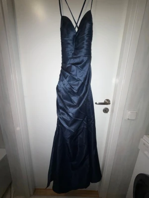 Balklänning/pris kan diskuteras  - Marinblå balklänning som tyvärr aldrig kom till användning då den var för liten. Köpt på JJ’S house för cirka 1400kr plus 300kr frakt. Storleken står inte på klänningen men har för mig att det var  34/Xs men vill man ha mer exakta mått så kan jag ta det! Får tyvärr inte lägga in bilderna från hemsidan och eftersom den inte passar mig kan jag inte visa den på men artikelnummret för den är #268688 om man vill se den på en person. Ser skrynklig ut på bilden men det rätar ut sig när den sitter på!