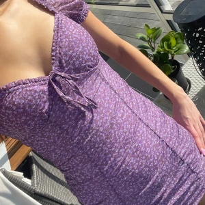 Lila blommig kortklänning - En supersöt tajt kortklänning från H&M, perfekt nu till sommaren!💜sparsamt använd!