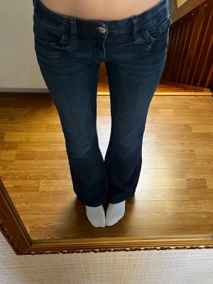 Lågmidjade jeans - Marinblå lågmidjade bootcut jeans från Gina Tricot Young i storlek 170, sitter som en S. Har resår i midjan. Endast använda enstaka gånger