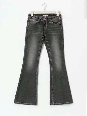 Svarta bootcut jeans från True Religion - Snygga svarta bootcut jeans med markerade kontrastsömmar och klassiska fickdetaljer bak. Jeansen har låg midja och utsvängda ben. Ifrån Gina Young 14+, jätte bra skick!!