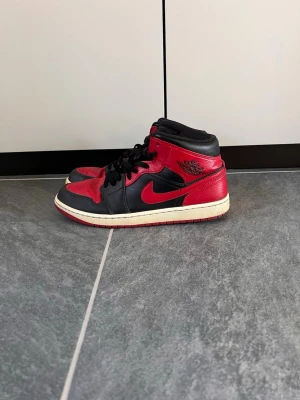 Jordan 1 Mid “Bred”  - Säljer mina Nike Jordan 1 Mid i den klassiska Bred colorwayen. Sjukt clean sko som passar till allt. Använda men fortfarande i bra skick och mycket kvar att ge.  • Bra skick • Sulorna fortfarande fina • Ingen box • Säljs billigt för snabb affär   Size: 45 pris: 800 kr  Frakt finns