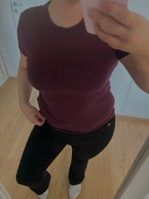 Mörklila basic t-shirt - En enkel och stilren mörklila t-shirt med rund hals och korta ärmar. T-shirten har en figurnära passform och är tillverkad i mjuk bomull, perfekt för en avslappnad och snygg look.