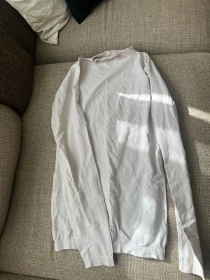 Vit långärmad tröja super stretchig - En basic vit långärmad tröja i mjuk tyg SUPER STRETCHIG Perfekt att ha som lager eller bara som den är. Enkel och stilren design med rund hals och normal passform. Har noppror som går att ta bort lätt me handen .😊pris kan diskuteras 