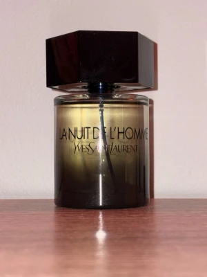 Yves Saint Laurent La Nuit De L'Homme - La Nuit De L'Homme från Yves Saint Laurent är en parfym i en stilren glasflaska med svart lock och mörk toning nedtill. Flaskan rymmer 100 ml och har en modern och maskulin design. Den är i princip helt ny!