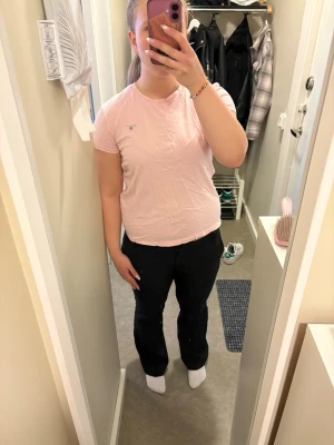 Ljusrosa GANT t-shirt i bomull - Säljer en ljusrosa t-shirt från GANT med liten broderad logga på bröstet. Klassisk rund halsringning och korta ärmar. Tillverkad i mjuk bomull som känns skön mot huden. Perfekt till jeans eller shorts för en enkel och clean look. Köpt från kidsbrandstore