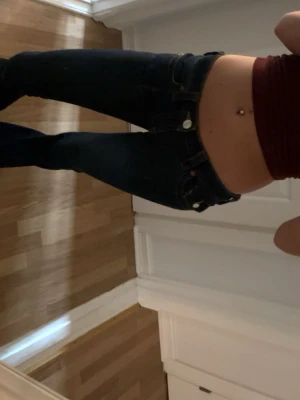 Mörkblå True Religion jeans bootcut - Säljer ett par mörkblå jeans från True Religion med klassisk bootcut-modell. Jeansen har tydliga kontrastsömmar, låg midja och ikonisk fickdesign med logga bak. Perfekta för dig som gillar en tidlös och snygg streetstil.