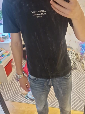Svart t-shirt med broderad text - Säljer en svart t-shirt från Athletic Club med broderad vit text på bröstet. Klassisk passform och korta ärmar. Perfekt till jeans eller shorts för en enkel och stilren look.