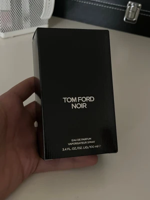 Tom Ford Noir Eau de Parfum 100 ml - Tom Ford Noir Eau de Parfum i en elegant svart rektangulär förpackning med stilren silvertext. Flaskan rymmer 100 ml och har en lyxig känsla som passar dig som gillar exklusiva dofter. Perfekt för dig som vill ha en sofistikerad och modern parfym.Ungefär 98ml finns kvar.