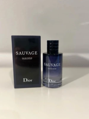 Dior Sauvage Eau de Parfum. Kan byta  - Dior Sauvage Eau de Parfum med elegant mörkblå glasflaska och svart lock. Flaskan har en stilren, rund form och kommer med originalkartong i svart med vit text. En ikonisk doft som utstrålar lyx och modernitet.