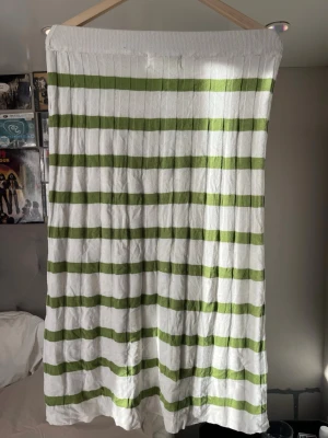 Randig långkjol från SAMSA Collection - Säljer en långkjol från SAMSA Collection med bred resår i midjan. Kjolen har gröna och vita horisontella ränder och är gjord i ett mjukt, ribbat bomullsmaterial. Perfekt för dig som gillar en avslappnad och trendig stil.