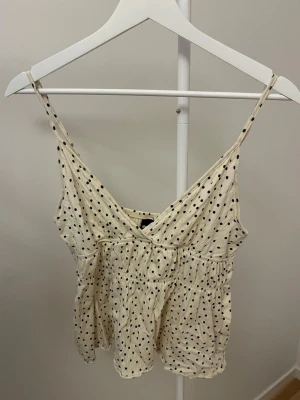 Polka dot topp - Säljer detta superfina prickiga linnet då den inte kommer till användning. Storlek M men passar mig bra som vanligtvis har S i toppar. Ser gulare ut på bilderna men är cremevit💞bara att höra av sig vid funderingar 