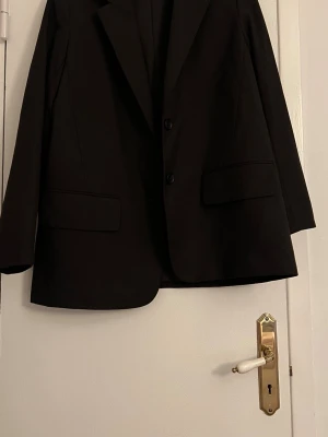 Svart oversized kavaj med två knappar - Stilren svart oversized kavaj med två knappar framtill och klassiska slag. Använd en gång. 