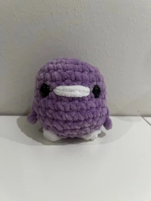 Lila anka  - Säljer en handvirkad liten anka i lila garn med vita detaljer på näbb och fötter samt svarta ögon. Perfekt present till någon som du gillar eller till dig själv. Materialet är mjukt, 8 cm hög och 6 cm bred. Pris går att diskutera.