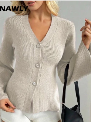 Beige kofta med v-ringning och knappar - Trendig beige kofta  med v-ringning och tre stora knappar framtill. Koftan har långa, lätt utsvängda ärmar och ribbade muddar. Tillverkad i mjukt stickat material som ger en skön och avslappnad look.