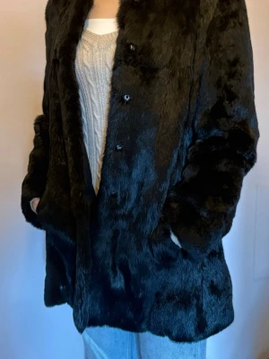 Black Vintage Fur Coat by Pap’Kik Paris - Hey! I’m selling this black vintage fur coat from Pap’Kik Paris. It’s a 100% rabbit fur, really warm and cozy. It says size 40 on the label, but the girl on the picture is a size S/M and it fits perfectly on her! Feel free to contact me with any further questions. :)