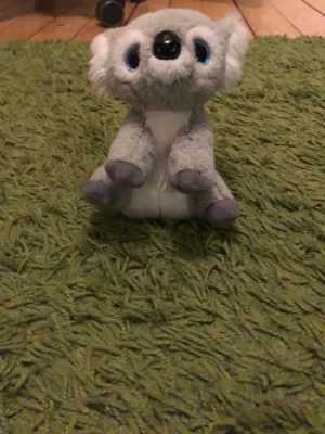 Mjuk koala gosedjur - Söt koala i plysch med grå och vit päls, stora blå ögon och mjuk nos. Perfekt som kramkompis eller dekoration i rummet. Tillverkad i mjukt tygmaterial och har detaljerade tassar i mörkare grå färg.