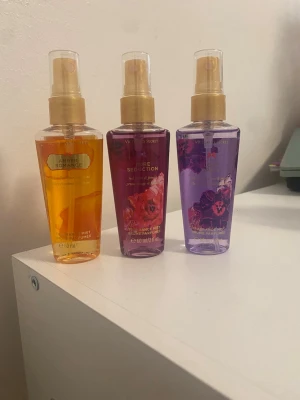 Victoria's Secret doftmist 3-pack - Säljer tre doftmister från Victoria's Secret: Amber Romance i orange flaska, Pure Seduction i rödrosa flaska och Love Spell i lila flaska. Alla flaskor är 60 ml och har guldiga spraymunstycken. Perfekt för dig som vill ha olika fräscha dofter att välja mellan.