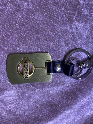 Bil Nyckelring  - Unik nyckelring i metall med Nissan-logga på ena sidan och Renault-logga på andra. Rektangulär form med guldfärgad finish och svart läderdetalj. Perfekt accessoar för bilentusiasten som vill ha något personligt till sina nycklar.  79kr/st  helt ny 