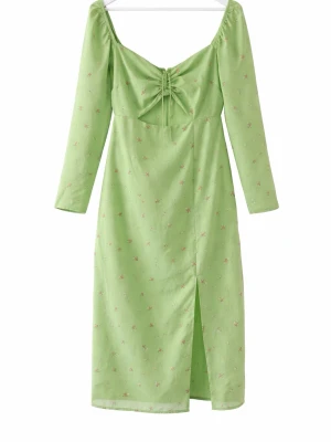 Grön blommig långklänning med snörning - Snygg ljusgrön långklänning med små blommor, v-ringad urringning och snörningsdetalj framtill. Klänningen har långa ärmar och en slits framtill för extra stilpoäng. Perfekt för vår och sommar, tillverkad i ett mjukt bomullsliknande material. Se skador på bilderna 