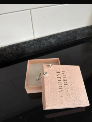 Armband Caroline Svedbom - Helt nytt, aldrig använt. Silvrigt med silvrig sten