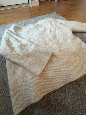 stickad tröja från gina tricot - Beige of shoulder stickad tröja från gina tricot. Mycket bra skick men är lite stickig, passar perfekt med ett linne under. 