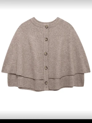 Beige ponchotröja med knappar - Ponchotröja i mjuk beige ullmix med ribbade kanter och knäppning framtill. Oversize passform som ger en avslappnad och trendig look. Perfekt att slänga över en outfit för extra värme och stil. Aldrig använd. Funkar storlek 36-38