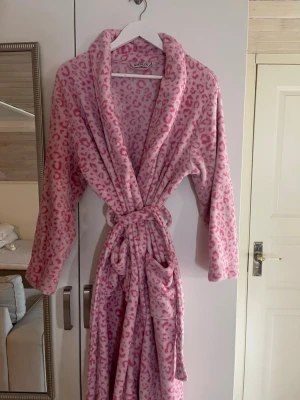 Rosa leopardmönstrad morgonrock - Supermysig och skön morgonrock med skärp i midjan och två fickor ifram.