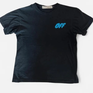 Off-White x Jordan Tom & Jerry T-shirt - Svart t-shirt från Off-White med blått 'OFF'-tryck fram och stor Tom & Jerry x Jordan grafik på ryggen. Rund hals och korta ärmar. Materialet är mjuk bomull och passformen är normal. Perfekt för dig som gillar streetwear och unika samarbeten. Köptes för 380€ ca 1 år sedan