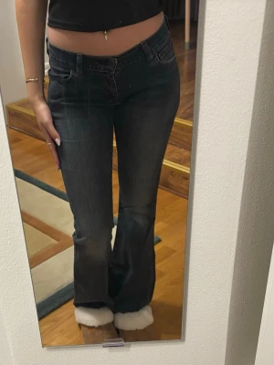 Mörkblå bootcut jeans - Säljer ett par mörkblå bootcut jeans med låg midja. Jeansen har en lätt utsvängd passform för en trendig look. Perfekta till sneakers eller boots.