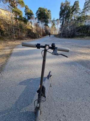 Svart elscooter med digital display - Säljer en svart elscooter med stilren design och digital display på styret som visar hastighet och batterinivå. Scootern har grå handtag, ringklocka och robust ram i metall. Perfekt för smidig transport i stan eller till skolan. Den åker 25km/h