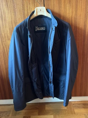 Blazer från Herno - Vårjacka / Blazer i tekniskt material från Italienska premiummärket Herno. Inköpt på Gabucci 2025. Nypris 6 999 kr. Storlek 52. Liten i storleken, jag har alltid strl 50 annars. Använd ett fåtal gånger, mycket bra skick.