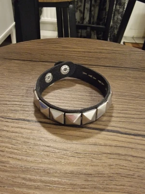 Armband punk pyramidnitar - Armband punk pyramidnitar. Längd 22,2 cm. Bredd 1,5 cm. PU läder.