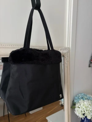 Vintage Lancôme Faux Fur Tote Bag - Rare  - Rare vintage bag from Lancôme Originally received as an airline gift set +25 years ago – now a unique statement piece  Details: •Brand: Lancôme •Era: Vintage (approx. late 90s / early 2000s) •Color: Black •Material: Fabric with faux fur trim •Shoulder straps •Spacious – fits daily essentials  Condition: •Good vintage condition •Clean inside •Some minor signs of wear due to age   Why it’s special: •Not sold in stores – limited / promotional piece •True vintage with history    vintage bag, y2k bag