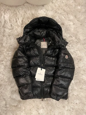 Moncler Maya ÄKTA - Säljer nu min Moncler Maya i storlek 1, vilket motsvarar XS/S! Jackan är köpt på NK i Stockholm, prislappen finns kvar som visas på bilderna! JACKAN ÄR SJÄLVKLART ÄKTA! Bild på det fysiska kvittot finns som stämmer överens med prislappen. Finns få flaws, cartoonen har släppt lite på höger sida, ett litet pinhole på vänster arm som knappt syns, samt ett lite skrapmärke på en knapp vid ärmen. Utöver det är jackan i fint skick och varsamt använd! Exakta bilder på detta och andra önskemål kan fixas!