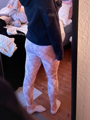 Beige camo leggings från Johaug  - Säljer ett par snygga leggings från Johaug i beiget, rosa och vitt camomönster. De har mellan hög midja och sitter tight, perfekta för träning eller chill. Materialet är stretchigt och följsamt för bästa komfort. Super sköna och sitter perfekt, super sköna. Storlek M. 