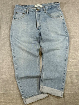Wrangler Baggy Fit W36  L30 High Rise Vintage Wash Workwear Fit - Wrangler light wash jeans W36. High rise with relaxed straight fit = clean baggy look. Vintage wash with natural fade + raw hem for that worn-in vibe. Heavy cotton denim, built to be used. Easy workwear or streetwear piece.  Measurements: waist 46.5, rise 30, thigh 34, knee 27, foot 21, length 104.5 cm  Good used condition.