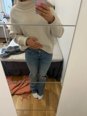 Ljusblå slitna jeans med hål - Säljer ett par ljusblå jeans med raka ben och stora slitningar vid knäna. Från Nelly och helt oanvända!