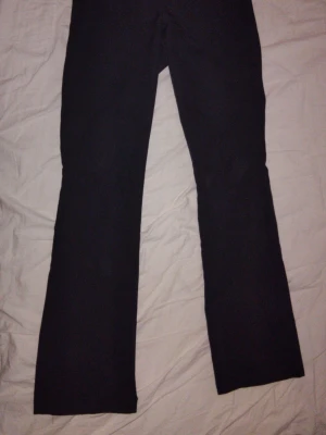 Svarta kostymbyxor från Bik Bok - Säljer ett par svarta kostymbyxor från Bik Bok i storlek 36. Byxorna har utsvängda ben, dragkedja och knapp framtill samt diskreta fickor. Materialet är mjukt och har en lätt stretch för extra komfort.