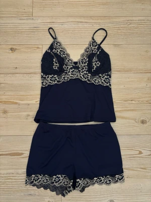 Pyjamas set - Jättegulligt pyjamas-set med shorts och linne! Navy blå med vita spetsdetaljer!🎀 Sparsamt användt! Storlek M men passsar även S