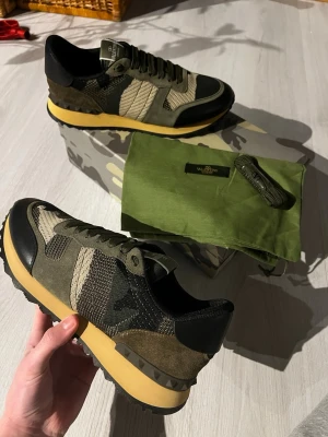 Valentino Garavani camo sneakers - Säljer dessa riktigt feta Valentino Garavanis i militärgrönt, perfekt till vintern. Dustbag, extra snörenen och boxen följer med. Skriv till mig vid funderingar, pris går att diskuteras vid snabb affär 💫