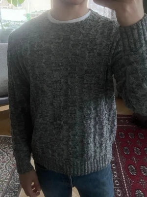 Grå stickad tröja från Only & Sons - Säljer en grå stickad tröja från Only & Sons med ett snyggt strukturerat mönster. Tröjan har rund halsringning, långa ärmar och ribbade muddar vid ärmslut och nederkant. Perfekt för lager på lager och chill stil. Storlek L men sitter som M
