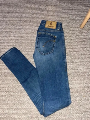 Blå slim fit jeans från Dandup - Tjena! Säljer nu ett par lite schysstare dondup. Jeansen är slim fit se passform på bilden ny pris ligger runt 2000kr mitt pris 499 pris kan sänkas vid en snabb affär.                                                    Storlek W26 passar ca 160-165cm 