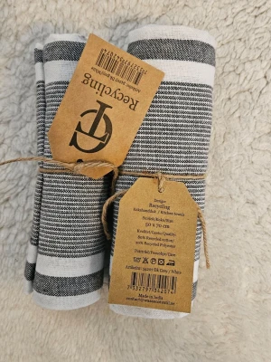 Randiga kökshanddukar i grått och vitt - Två kökshanddukar från Recycling i randigt grått och vitt. Tillverkade av 80% återvunnen bomull och 20% återvunnen polyester. Storlek 50x70 cm. Perfekta för köket och har en stilren design.