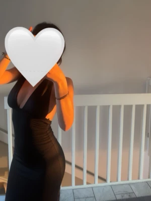 Svart långklänning med öppen rygg - Svart långklänning med djup v-ringning och öppen rygg. Klänningen har en tight passform och är ärmlös, perfekt för en snygg och stilren look. Materialet ser ut att vara mjukt och följsamt. Har använt den bara en gång.