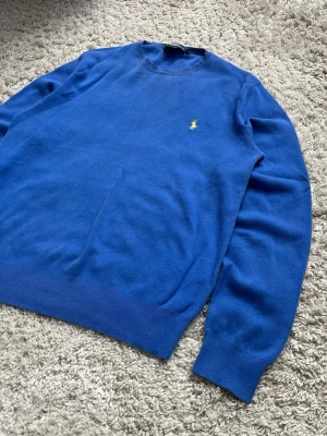 Blå Ralph Lauren pima bomull sweater / tröja, storlek L - Blå sweater från Ralph Lauren med gul logga i 100% pima-bomull.   Mycket bra skick, inga defekter och mycket fräsch  Storlek L