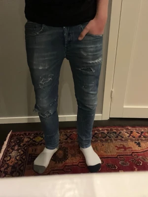 Dondup Jeans - DONDUP JEANS  Storlek : W30  Passform : George, skinny  Mått : A = 37CM - B = 95CM  Användning : Jeansen är i ett väldigt fint skick utan defekter  Nypris : Cirka 3500SEK. Jeansen har ett litet hål vi knät men det syns inte på bilden